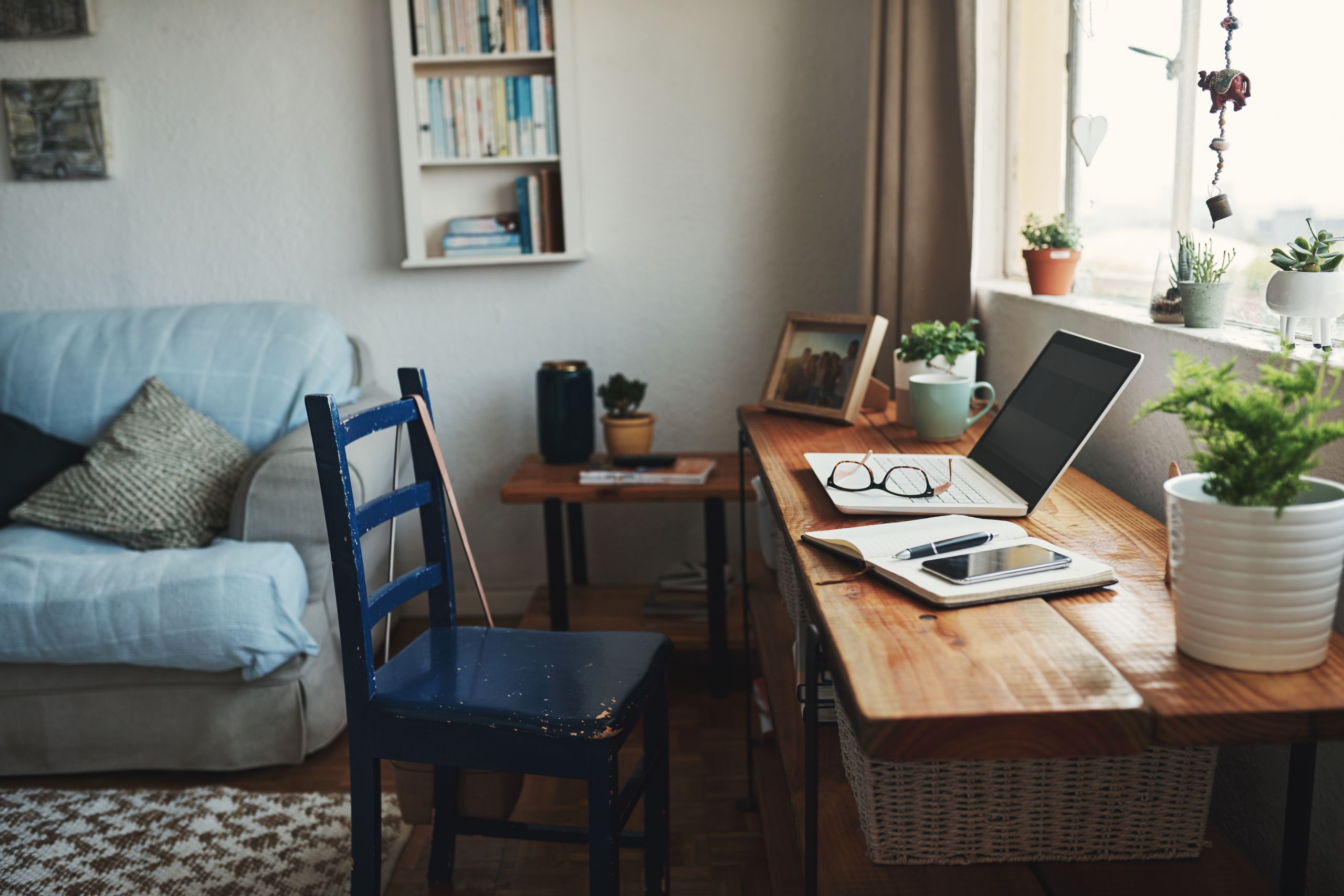 Image of a desk with a laptop and notebook on the table
