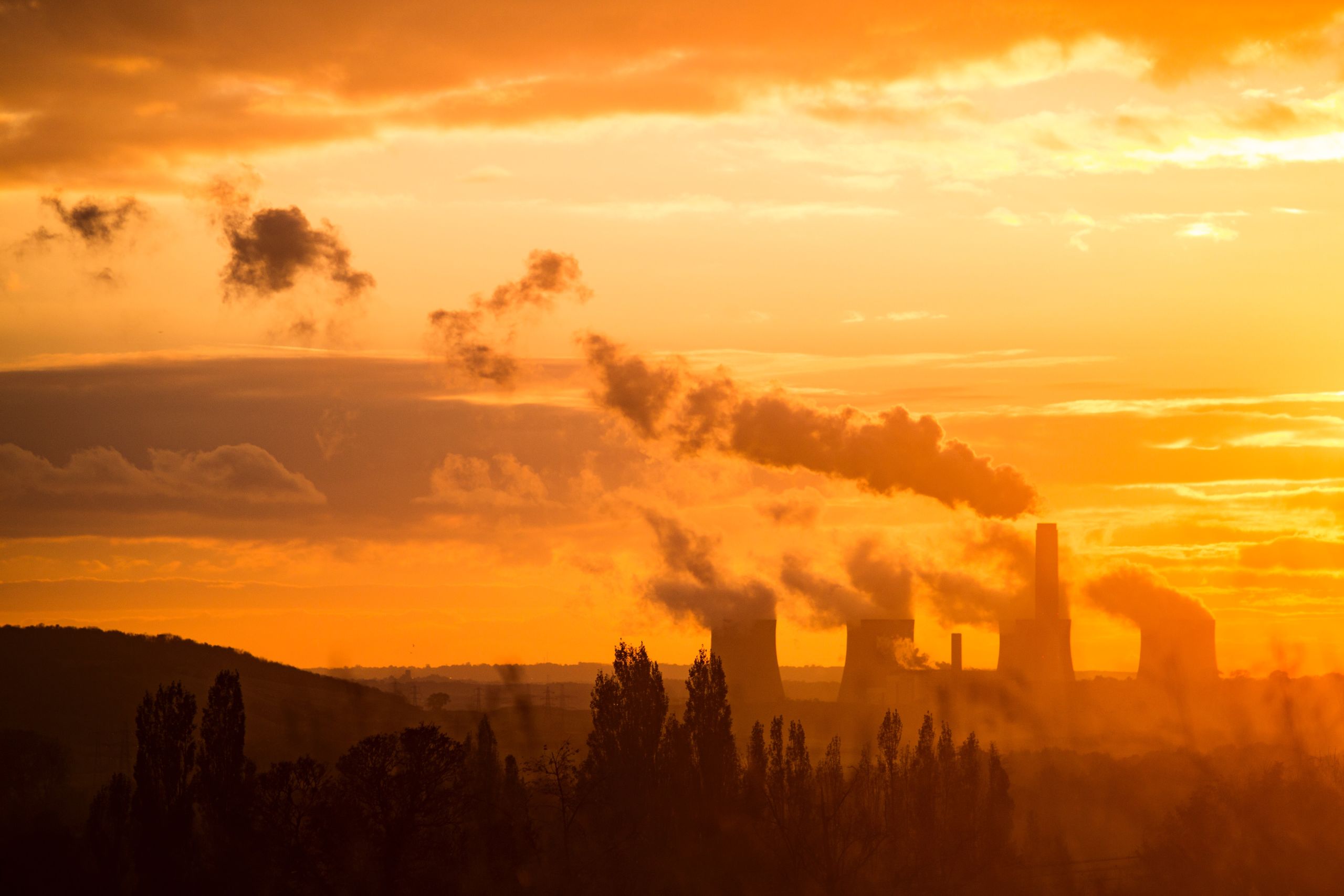 Red sky with power stations emitting smoke