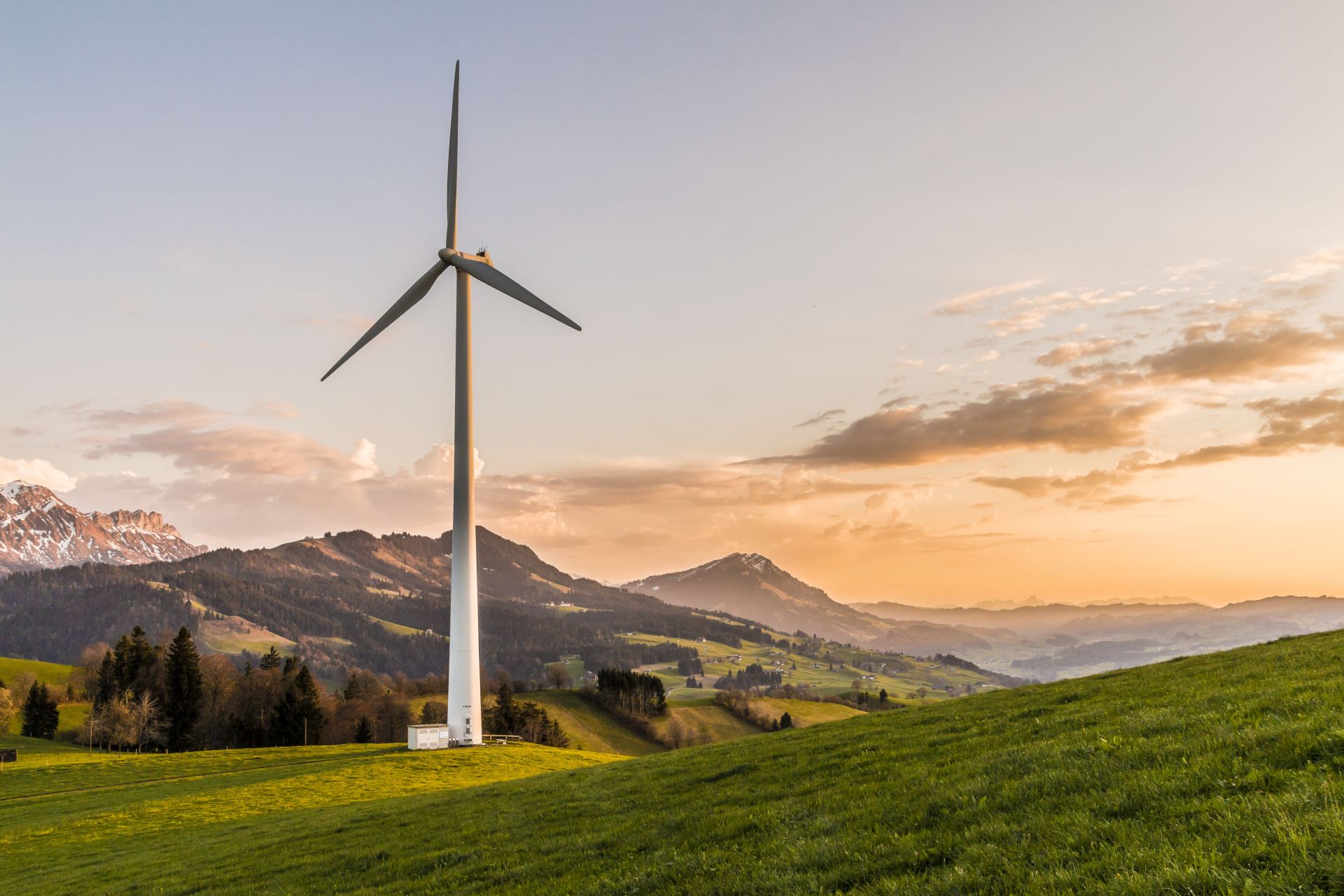 photography of white Windmill on valley under cloudy sky