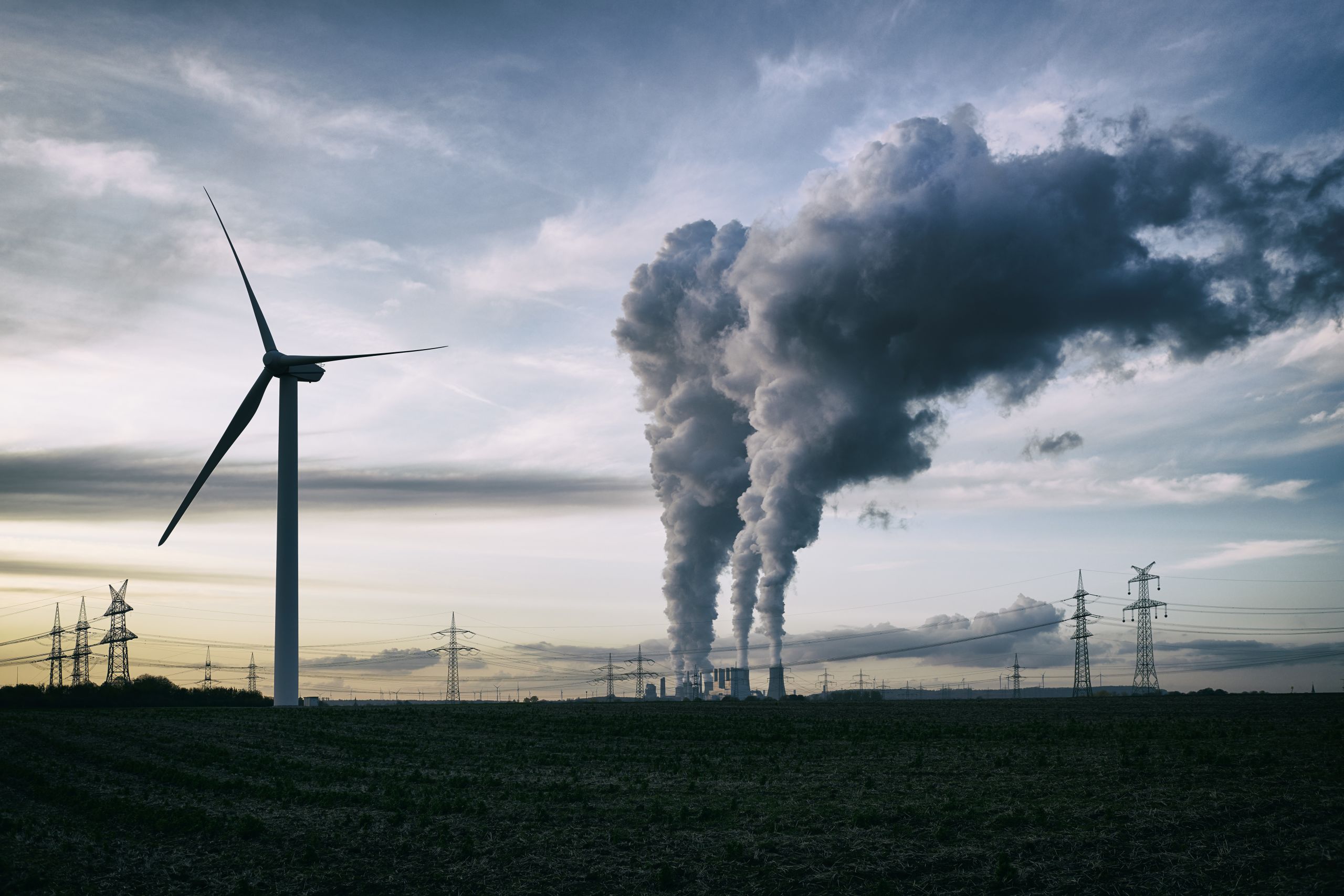 Windmill next to coal power plant