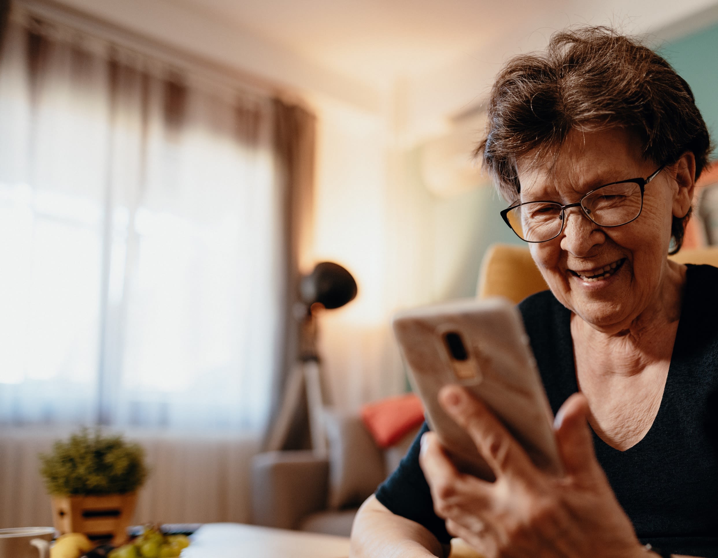 Elderly woman smiling at her smartphone