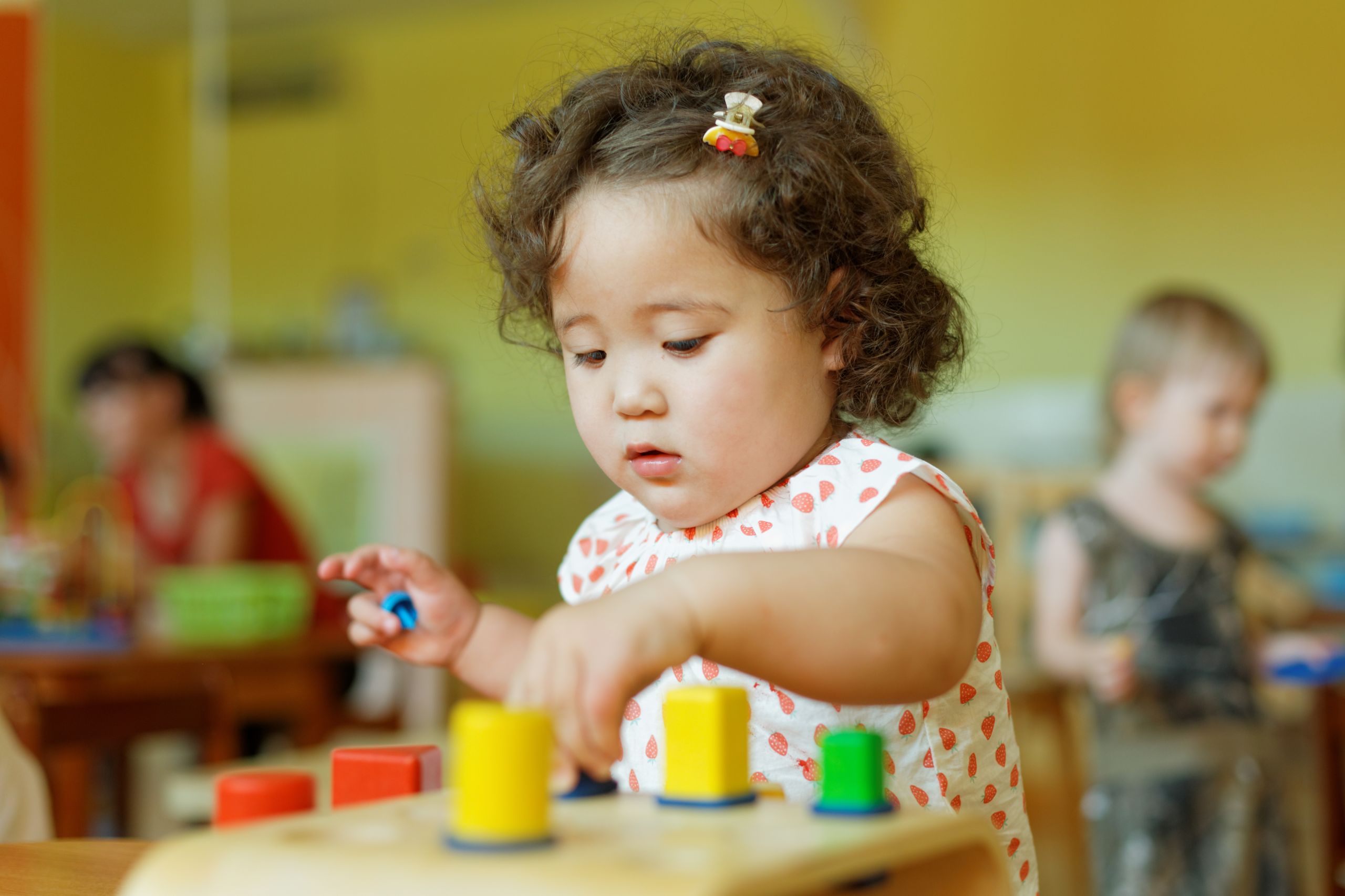 Toddler playing with blocks in a nursery.