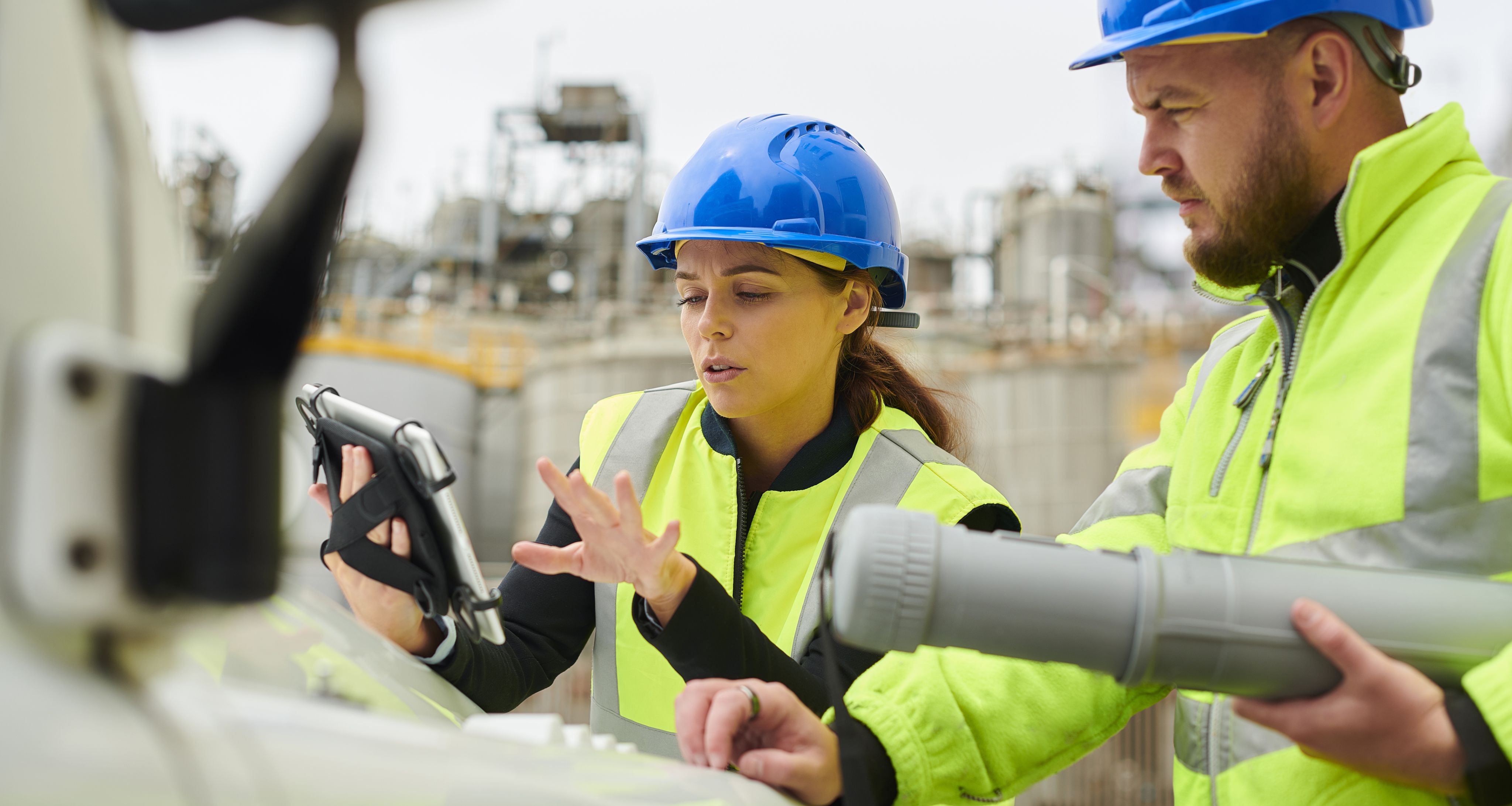 An image of two construction workers looking at an ipad.