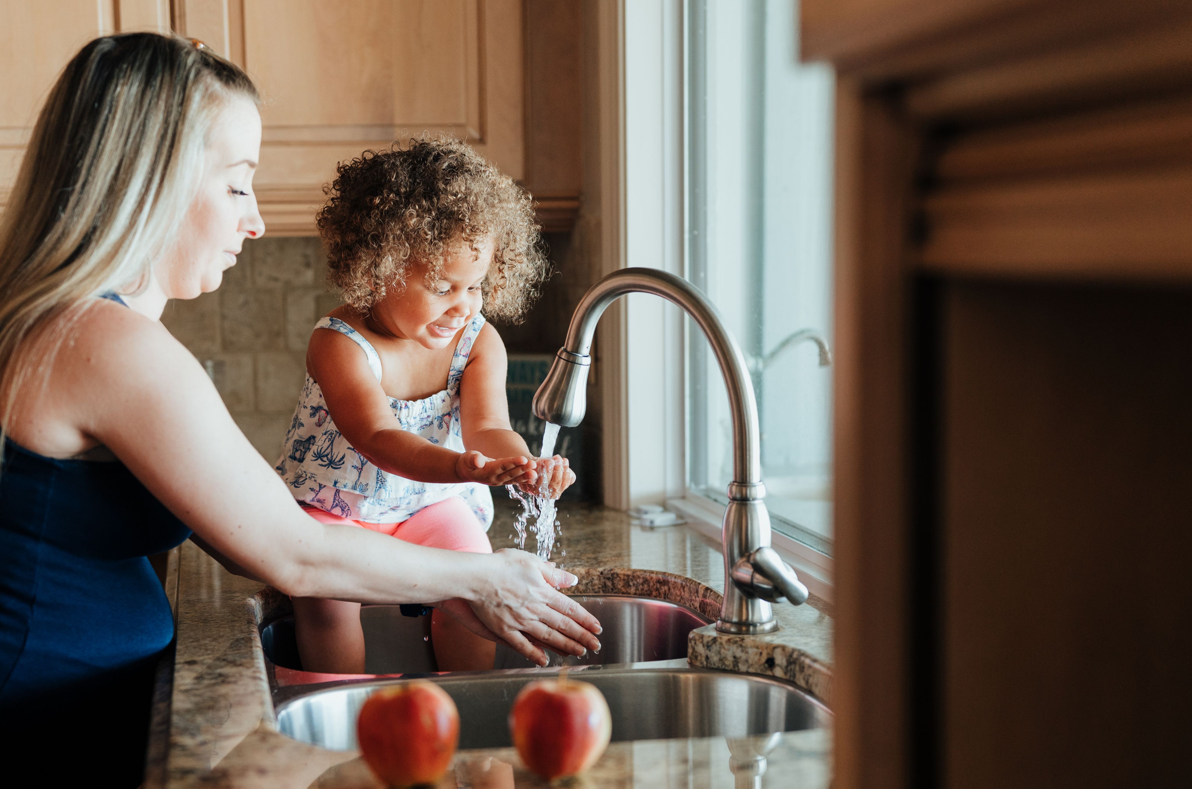 Photograph of mother and daughter washing hands in sink 