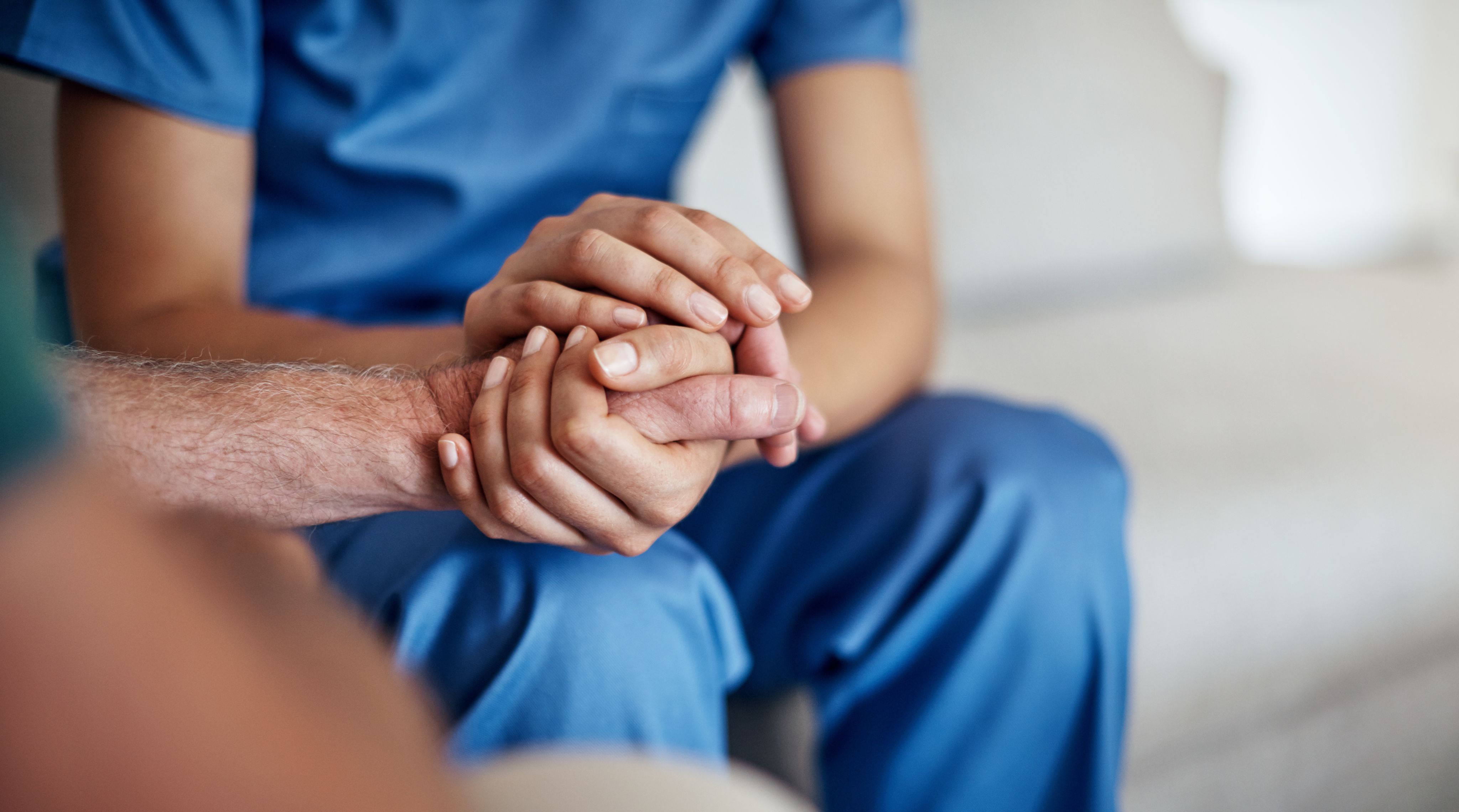 Nurse holding a patients hand