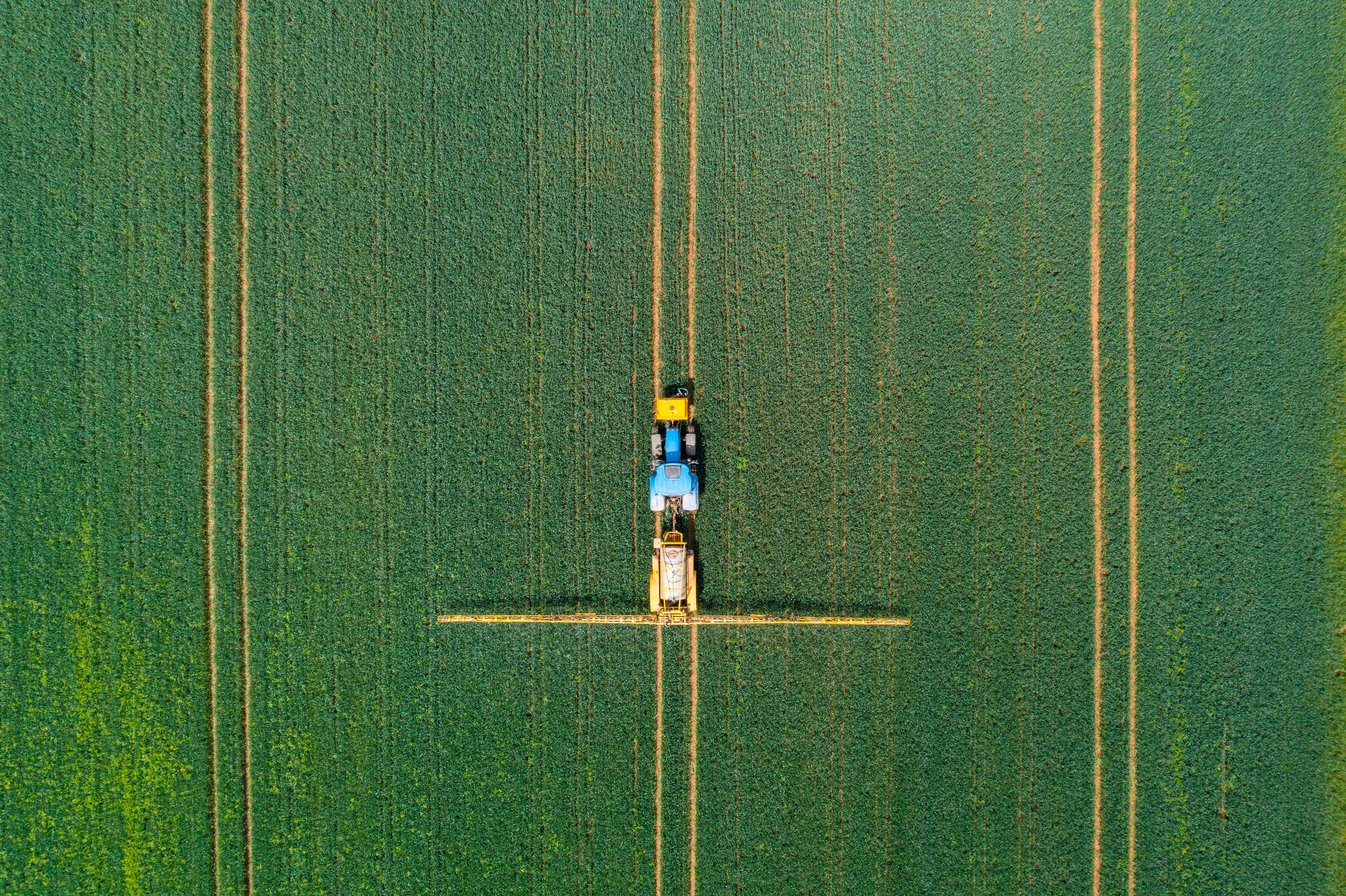 Aerial view of farming tractor crop sprayer in the countryside.