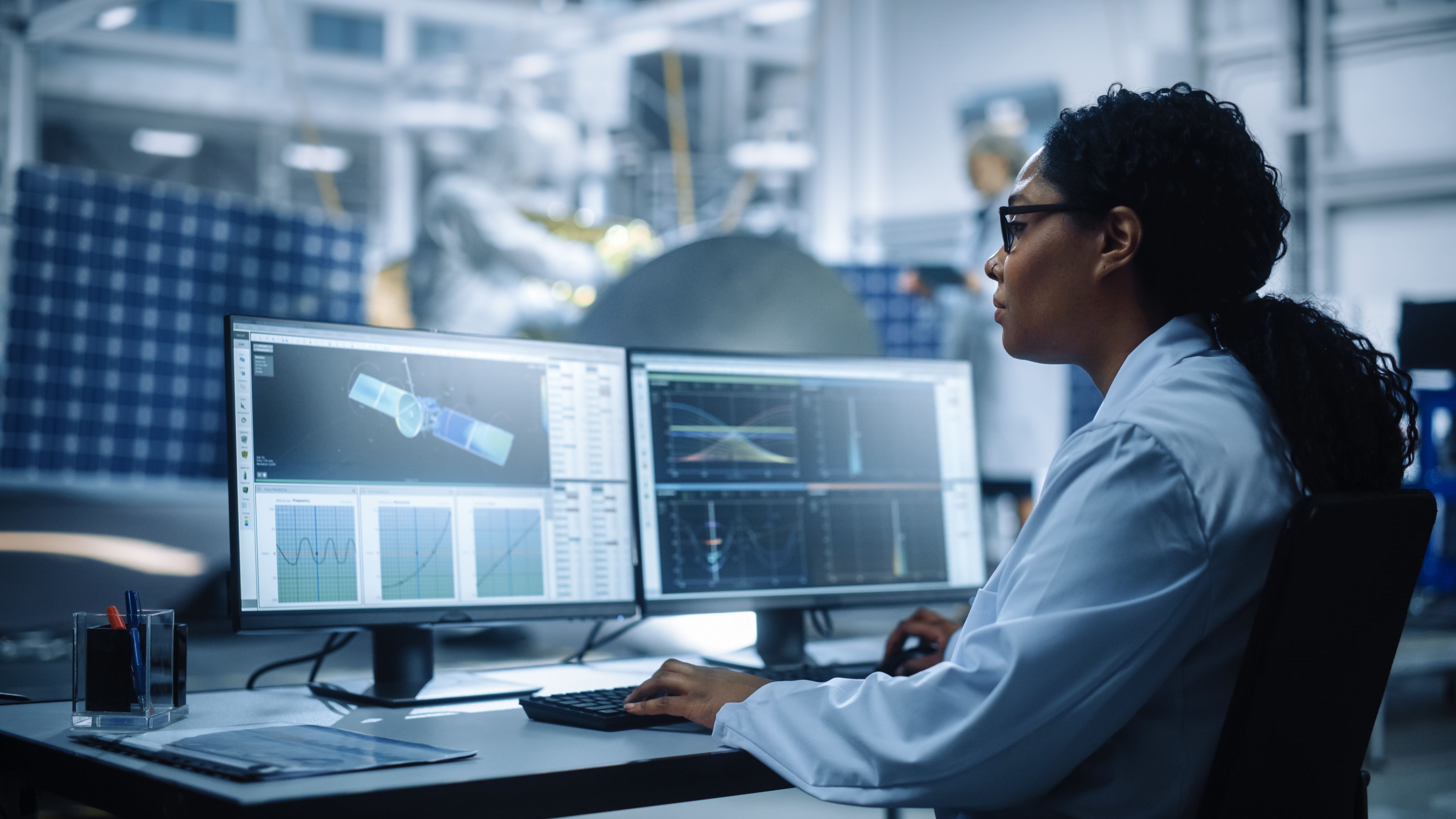female engineer using computer to analyse satellite