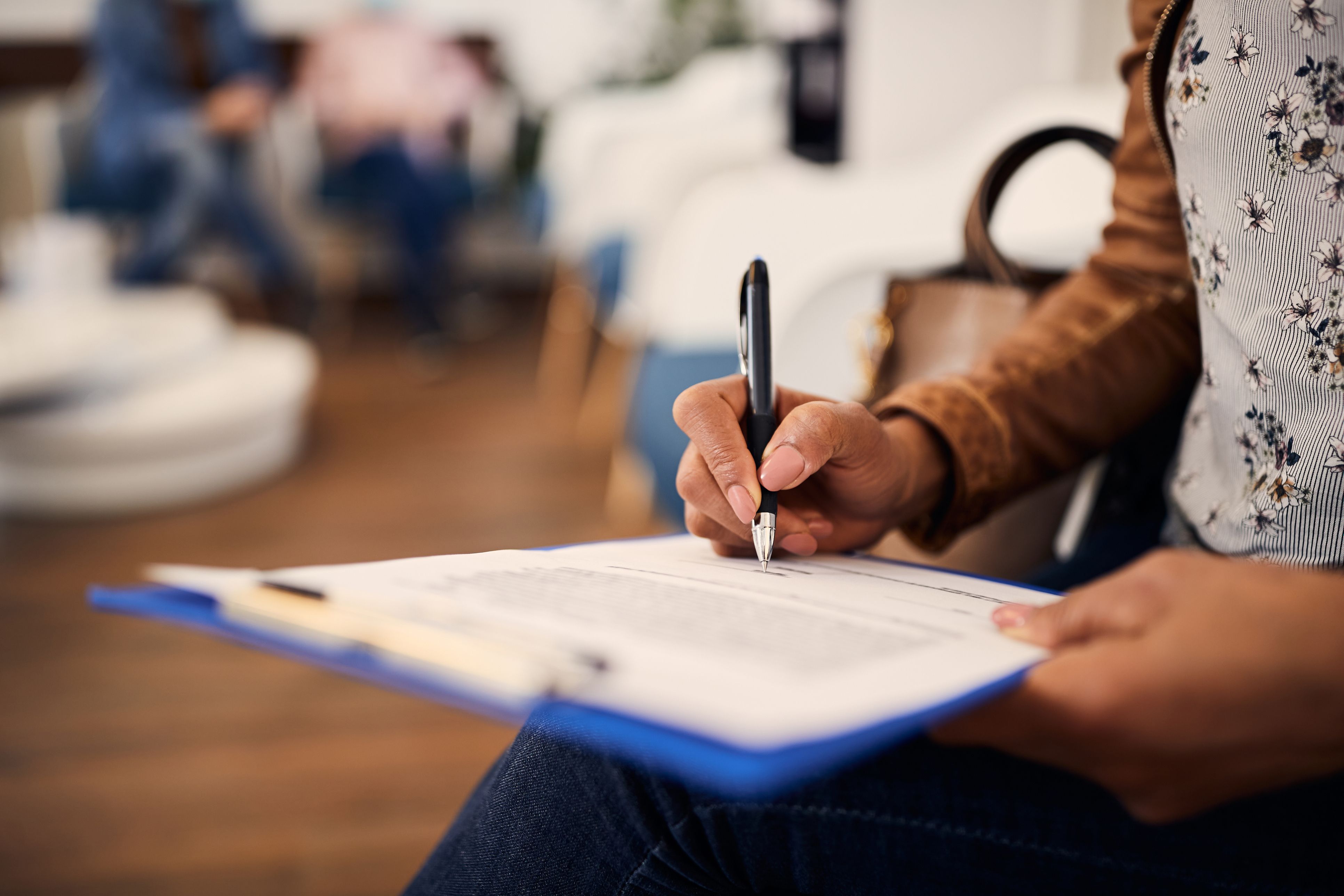 Close up on a person's hands as they take notes on a clipboard
