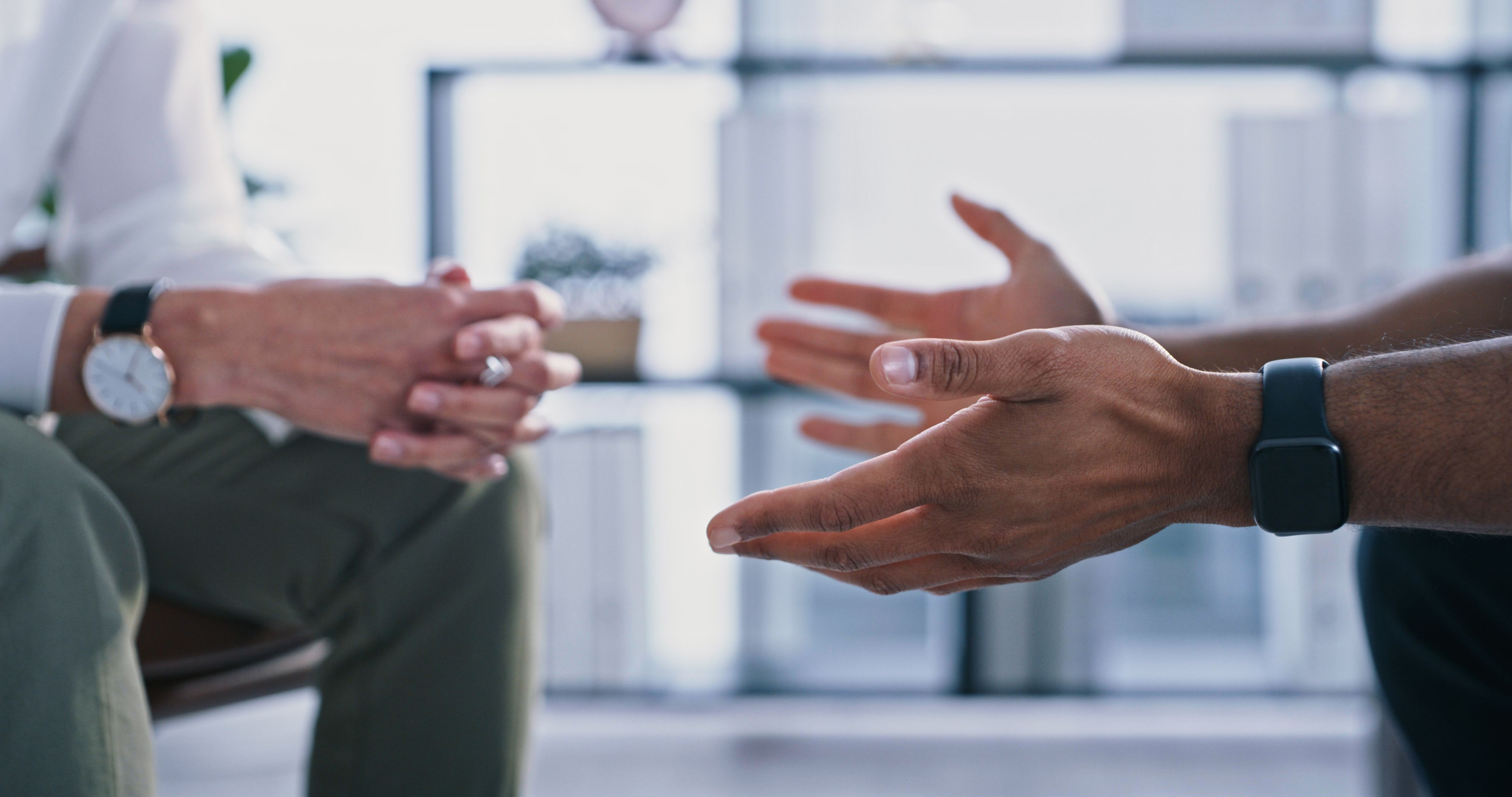 close up on two people's hands as they sit talking