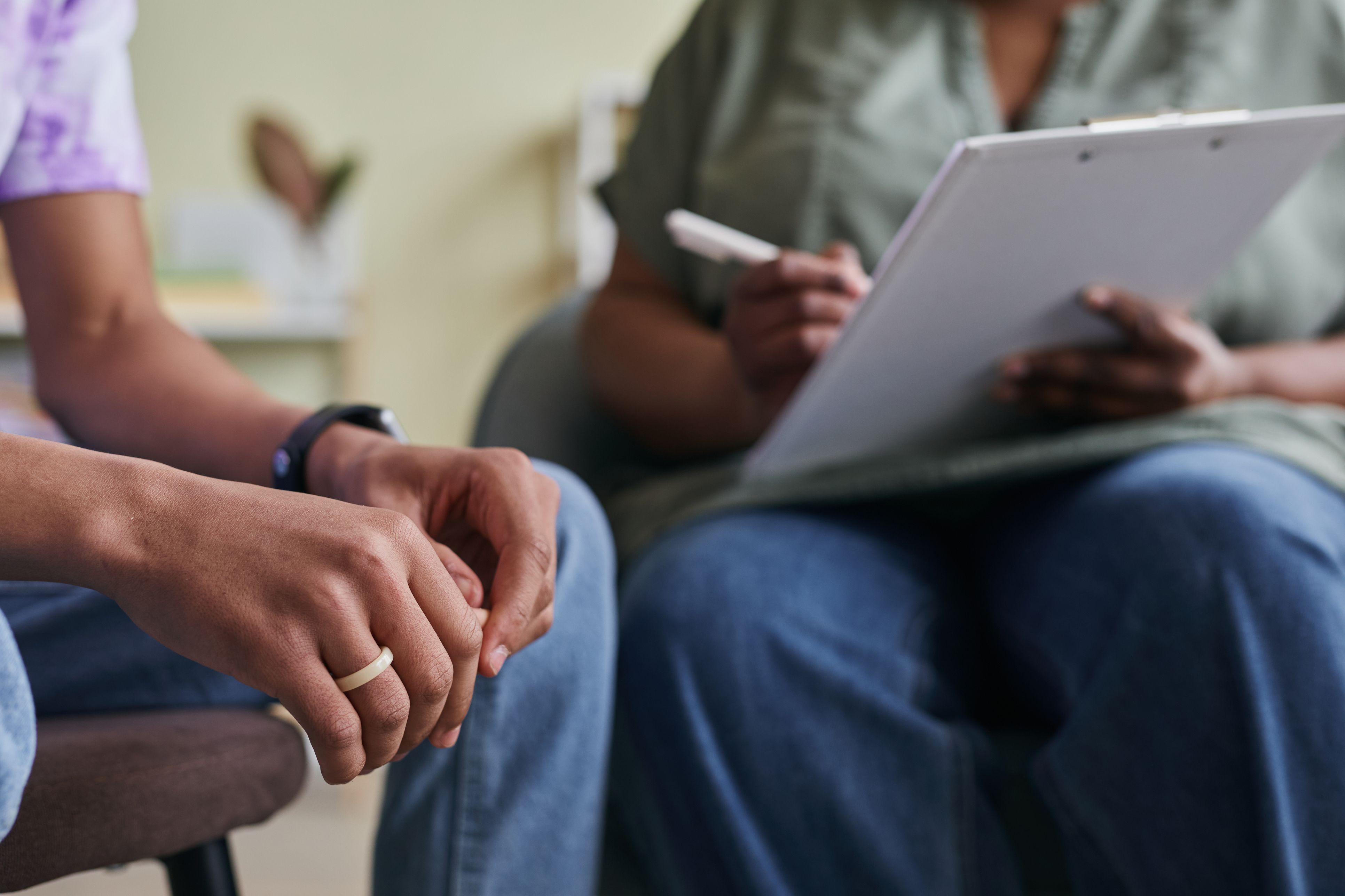 Close up on a person's hands as they speak to somebody holding a clipboard and pen