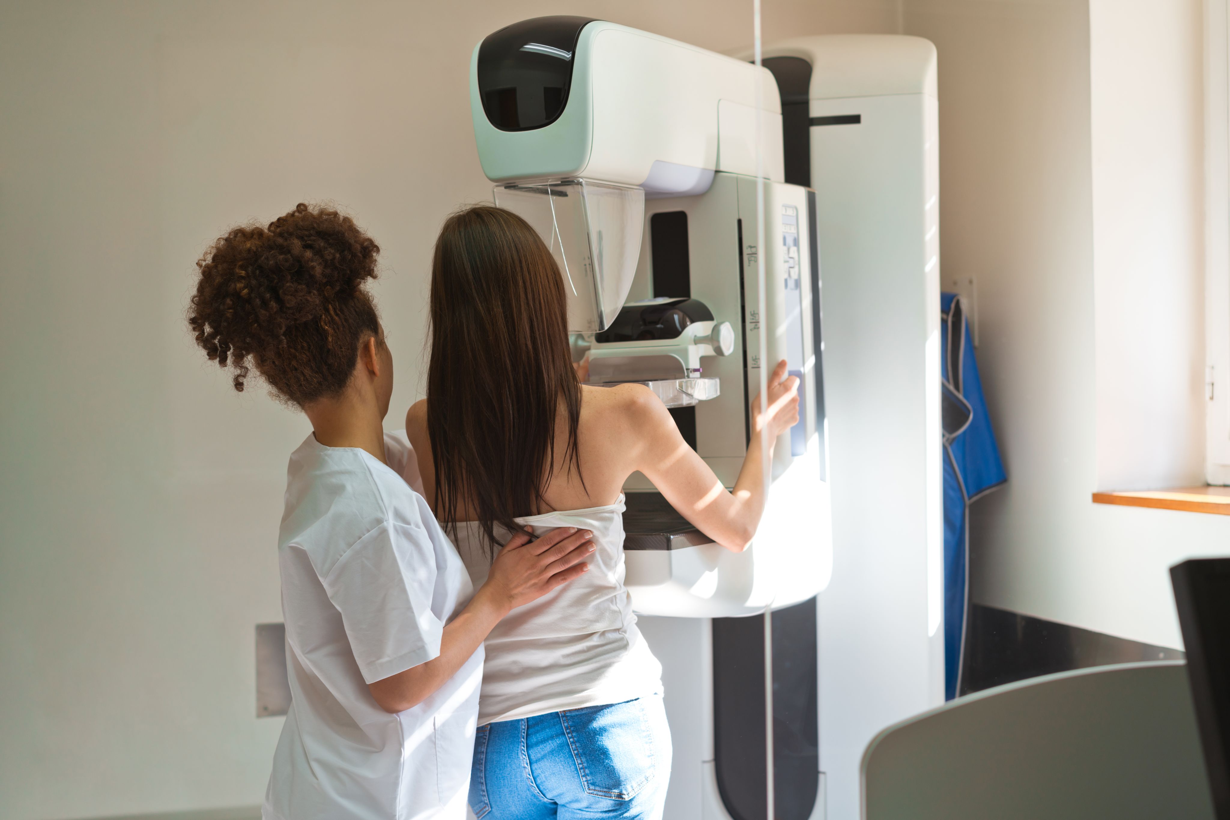 A female medical worker taking a mammogram from a young patient.