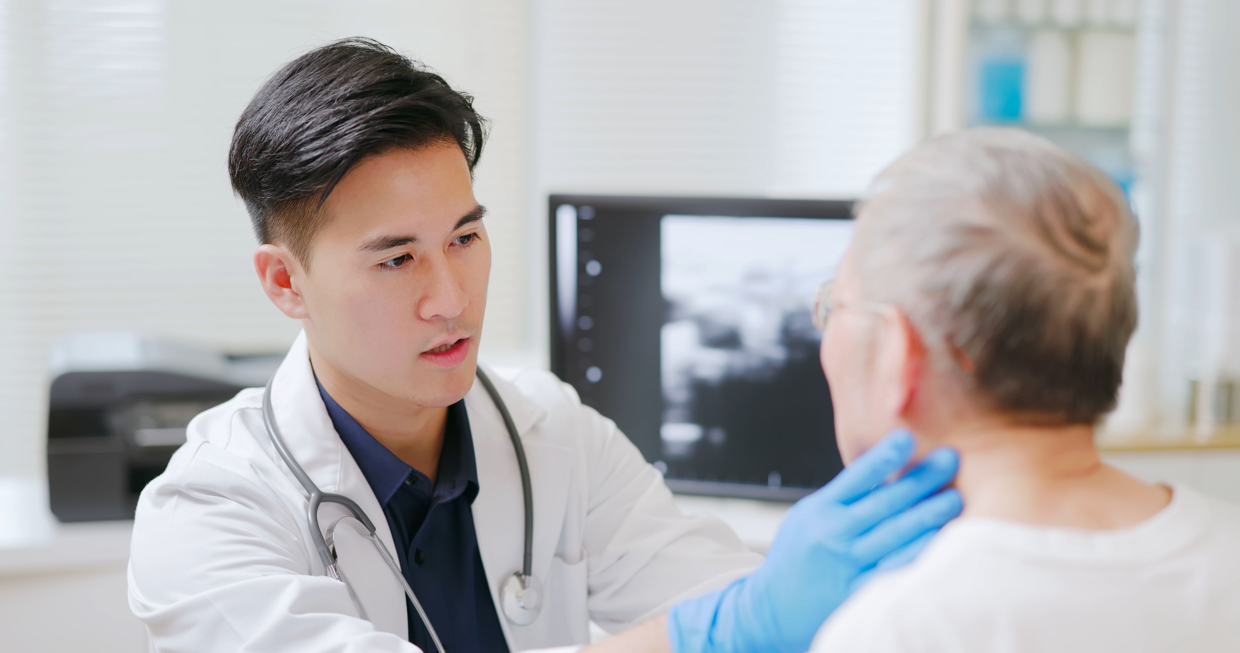 A medical worker checking a patient's neck.
