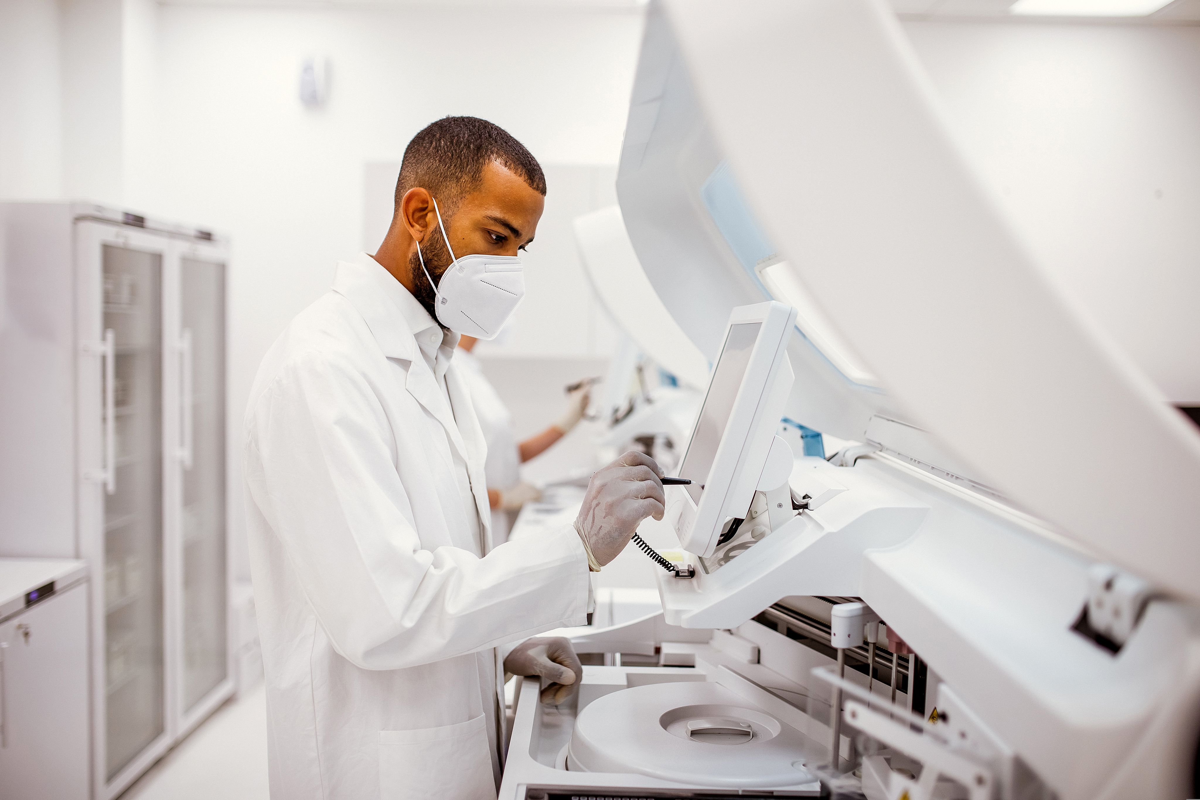 A clinical scientist working in a lab prepares a sample for analysis.